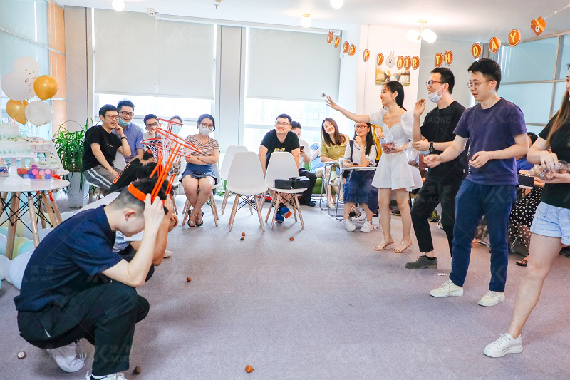 Employees play games happily at the birthday party